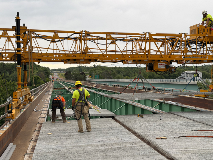 Construction Workers Moving Material On A Bridge
