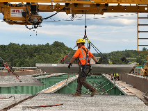 Construction Worker Placing Concrete Slab Using A Bid-Well MT-1 On A Bridge