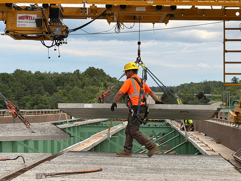 Construction Worker Placing Concrete Slab Using A Bid-Well MT-1 On A Bridge