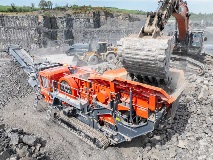 Crusher Being Loaded By Excavator