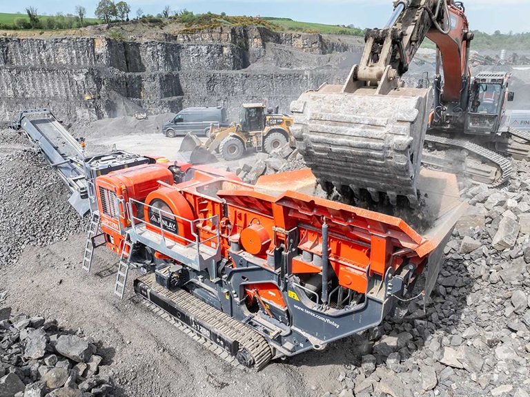Crusher Being Loaded By Excavator
