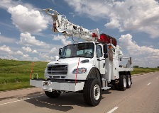 Terex Commander Digger Derrick driving down highway
