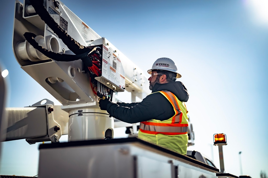Utility worker operating Terex bucket truck controls
