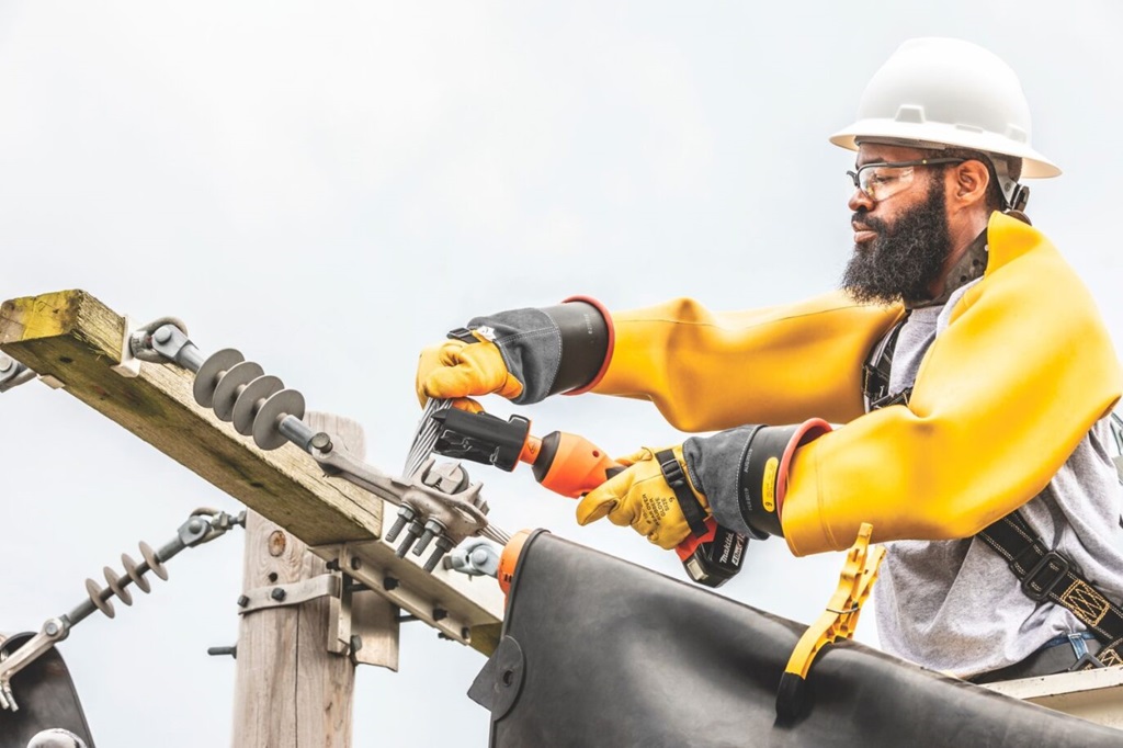 Lineworker using battery-powered tool