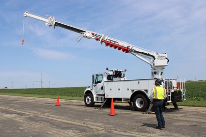 Utility worker operating digger derrick