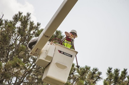 Lineworker using tools in bucket truck