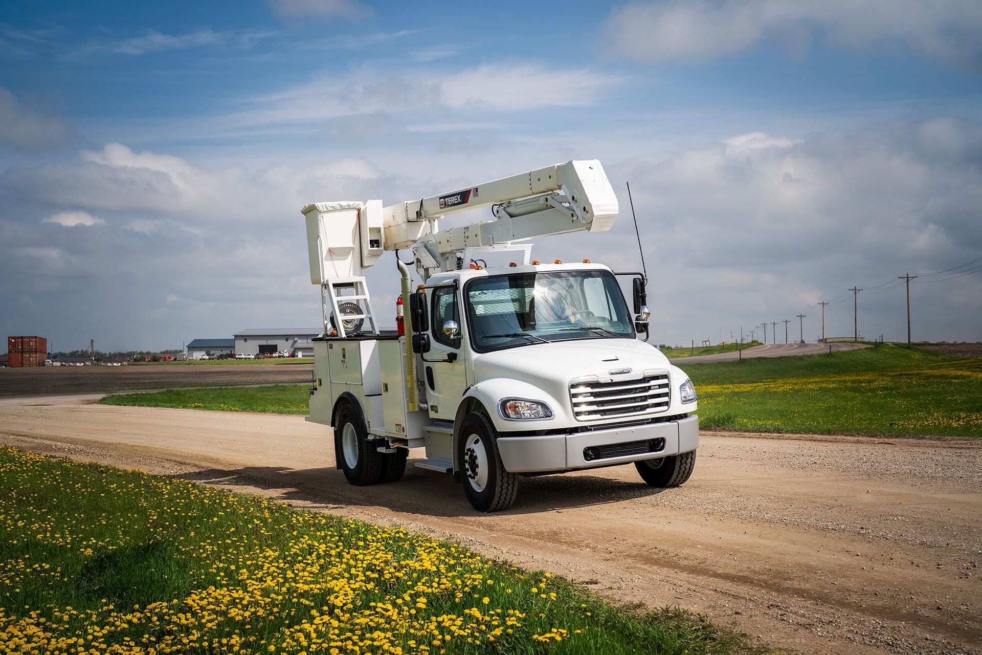 Terex bucket truck driving down gravel road