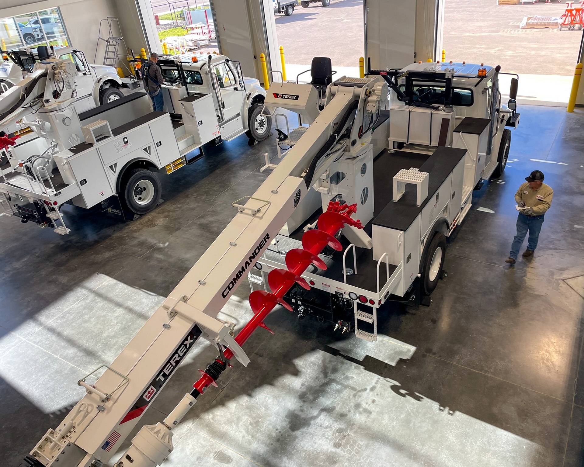 Mechanics inspecting Terex digger derricks