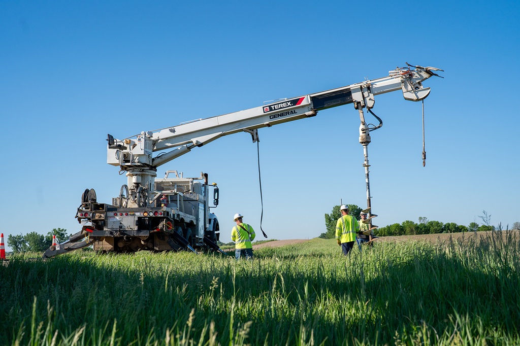 Lineworkers digging hole with Terex digger derrick